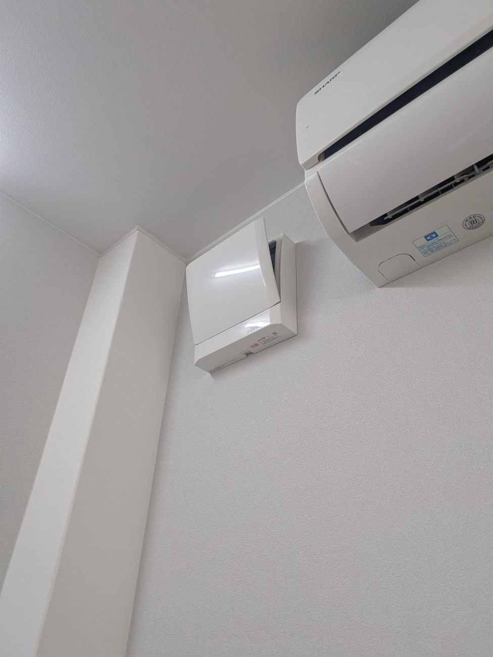 施工後、既存のエアコンの横に納まった換気ユニット